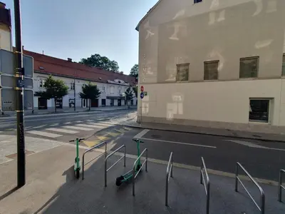 an empty city street with a building and a fence at Chic studios Wendy in centre Tour As Ljubljana in Ljubljana