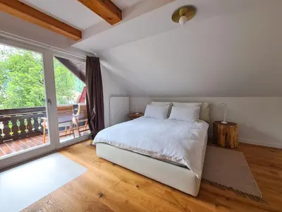 a bedroom with a bed and a large window at EROS APARTMENT Kranjska Gora in Kranjska Gora
