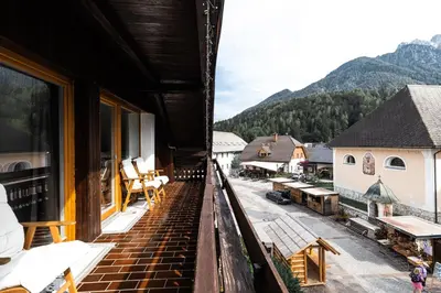 a balcony of a building with a view of a train yard at EROS APARTMENT Kranjska Gora in Kranjska Gora