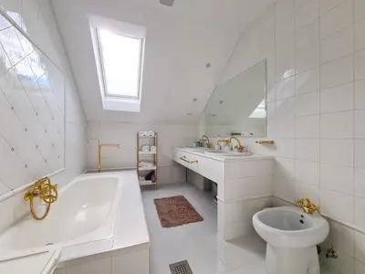 a white bathroom with a tub and a sink and a toilet at EROS APARTMENT Kranjska Gora in Kranjska Gora
