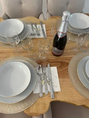 a table with white plates and a bottle of wine at EROS APARTMENT Kranjska Gora in Kranjska Gora