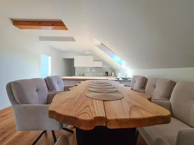 a dining room with a wooden table and chairs at EROS APARTMENT Kranjska Gora in Kranjska Gora
