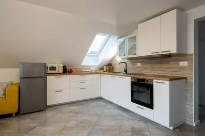 a kitchen with white cabinets and a window at Aparthouse Jana Breg in Žirovnica