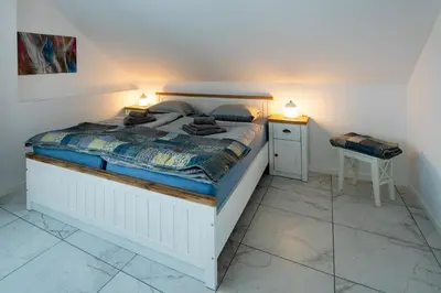 a bedroom with a large bed with two night stands at Aparthouse Jana Breg in Žirovnica