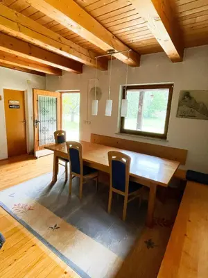 a dining room with a wooden table and chairs at Cabin in Nature in Nova Vas