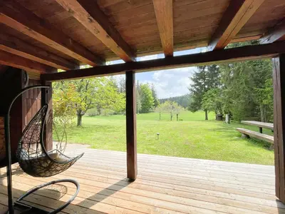 a porch with a hammock and a view of a park at Cabin in Nature in Nova Vas