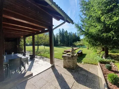 an outdoor patio with a table and a stone fountain at Cabin in Nature in Nova Vas