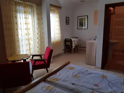 a room with a bed and a kitchen with a table at Apartments Gregorc in Bled