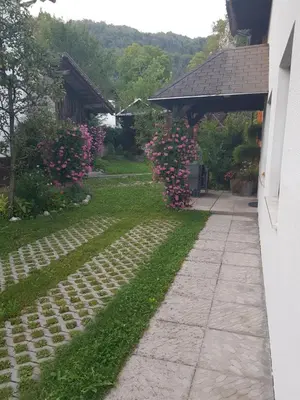a walkway leading to a yard with pink flowers at Apartments Gregorc in Bled