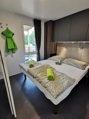 a bedroom with a bed with two green towels on it at Guesthouse Braslovče - Celje in Braslovče