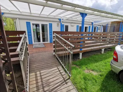 a wooden walkway leading to a house with a pergola at Guesthouse Braslovče - Celje in Braslovče