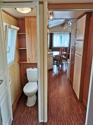 a bathroom with a toilet and a dining room at Guesthouse Braslovče - Celje in Braslovče