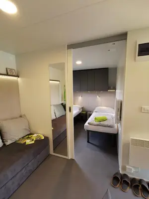 a small room with two beds and a mirror at Guesthouse Braslovče - Celje in Braslovče