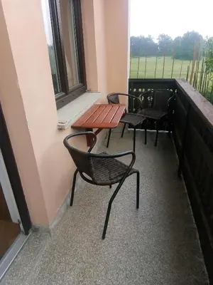 a balcony with two chairs and a table and a window at Apartments Boris in Bled