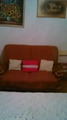 a brown couch with three pillows on it at Apartments Boris in Bled
