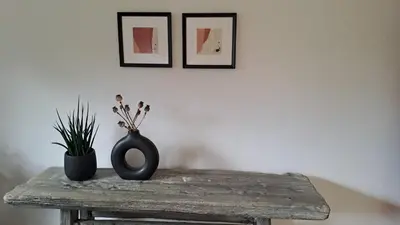 a table with a vase and a plant on it at FLAT FOR 2 - Alpine Dream Bled in Bled