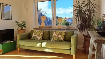 a green couch in a living room with a window at FLAT FOR 2 - Alpine Dream Bled in Bled