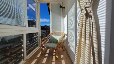a wicker chair sitting on a balcony with a window at FLAT FOR 2 - Alpine Dream Bled in Bled