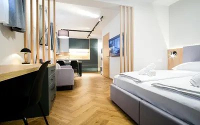 a hotel room with two beds and a desk at M16 Apartments in Ljubljana