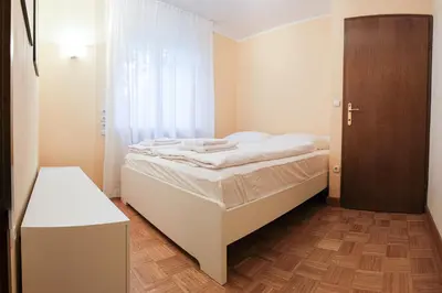 a small bedroom with a bed and a wooden floor at M16 Apartments in Ljubljana