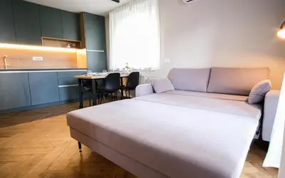 a bedroom with a bed and a table with chairs at M16 Apartments in Ljubljana