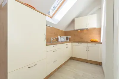 a kitchen with white cabinets and a skylight at Old Town first floor in Ljubljana