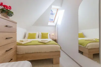 a bedroom with two beds and a mirror at Old Town first floor in Ljubljana