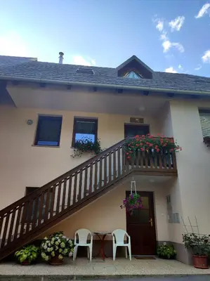 a house with a balcony with a table and chairs at Počitniško stanovanje Aurora in Bovec