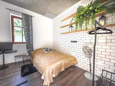 a bedroom with a bed and a brick wall at Riverside studio 1 in Ljubljana