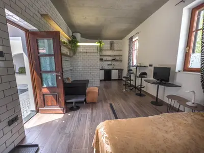 a room with a bed and a desk and a kitchen at Riverside studio 1 in Ljubljana
