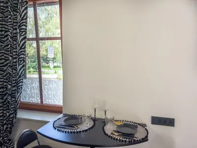 a dining room table with a blue table and a window at Riverside studio 1 in Ljubljana