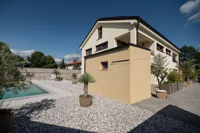 a house with a garage next to a swimming pool at Apartments Kras 24 with Pool in Sežana