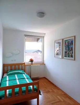 a bedroom with a bed and a window at Apartma AJDA in Velenje