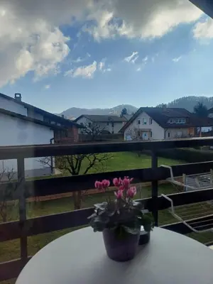 a table with a vase of flowers on a balcony at Apartma AJDA in Velenje