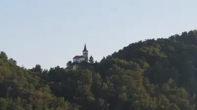 a lighthouse on top of a hill with trees at Apartma AJDA in Velenje