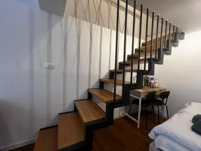 a staircase in a room with a table and a bed at Ljubljana Studios in Ljubljana
