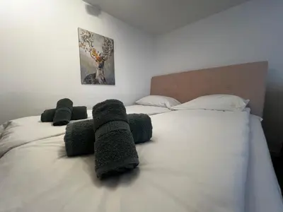 a bedroom with a large white bed with towels on it at Ljubljana Studios in Ljubljana