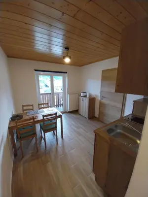 a kitchen and dining room with a table and chairs at Apartments at Klemen in Zgornje Gorje