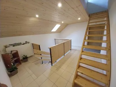 a room with a wooden staircase in a building at Apartments at Klemen in Zgornje Gorje