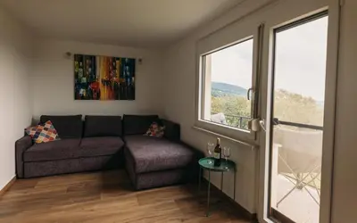 a living room with a couch and a window at Apartma Hiša na Ravnah with hot tub in Pišece