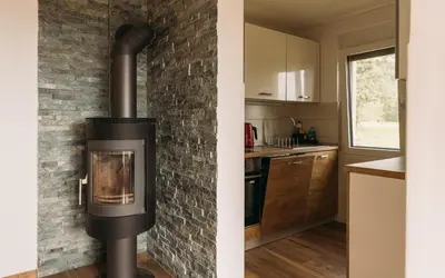 a fireplace in a kitchen with a brick wall at Apartma Hiša na Ravnah with hot tub in Pišece