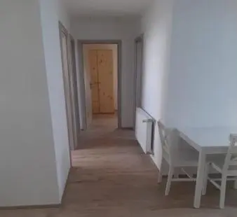 a hallway with a table and a chair in a room at Hisa jager in Gradišče v Slovenskih Goricah