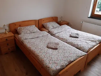 two twin beds in a bedroom with wooden floors at Hisa jager in Gradišče v Slovenskih Goricah