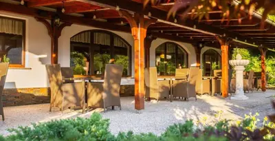 a patio with tables and chairs in a building at Nature Hotel Lukanc in Bled