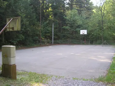 an empty basketball court with a basketball hoop at Camping Pivka Jama Postojna in Postojna