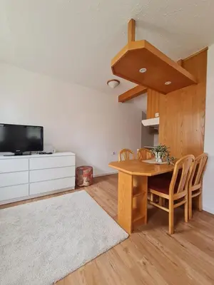 a living room with a wooden table and a tv at Apartment Moravske Toplice in Moravske Toplice