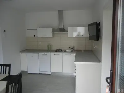 a white kitchen with white cabinets and a sink at Rooms Mira G in Postojna