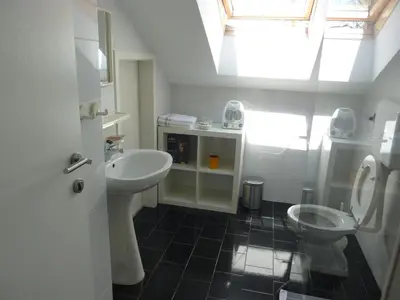 a white bathroom with a sink and a toilet at Rooms Mira G in Postojna