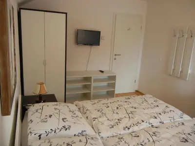 a bedroom with a bed and a tv on the wall at Rooms Mira G in Postojna