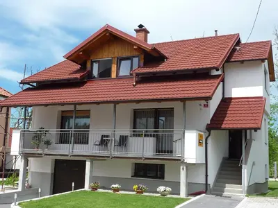 a house with a red roof and a balcony at Rooms Mira G in Postojna